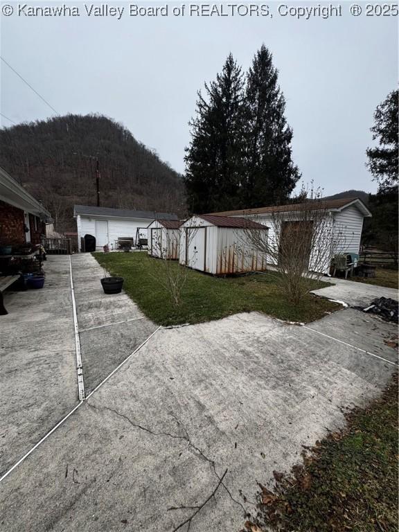 81 Amburgey Ln, Amherstdale, WV 25607 - view of front of property featuring a front lawn, an outbuilding, a mountain view, and a storage unit