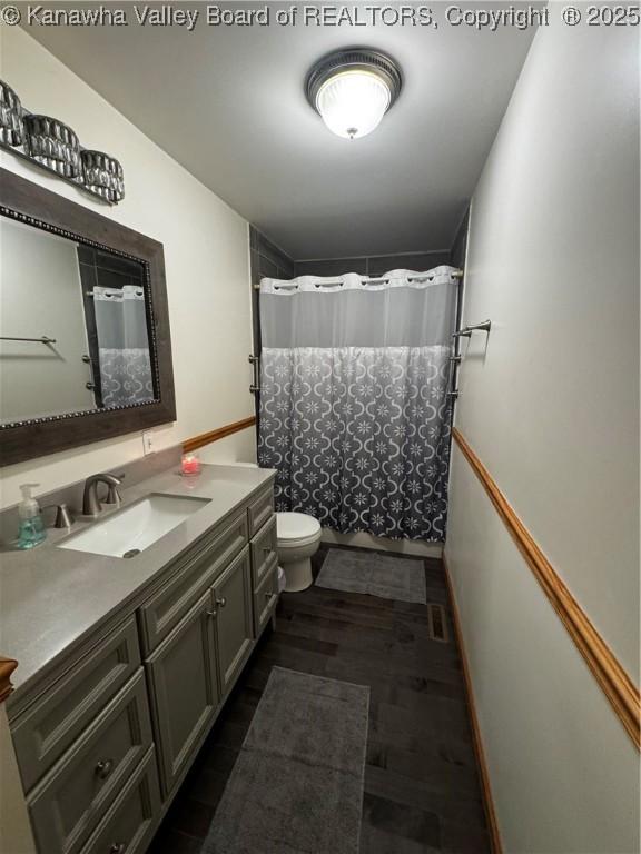 81 Amburgey Ln, Amherstdale, WV 25607 - full bath featuring vanity, a shower with shower curtain, toilet, and wood finished floors