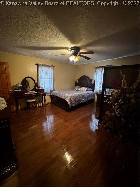 81 Amburgey Ln, Amherstdale, WV 25607 - bedroom with dark wood-style flooring, ceiling fan, and a textured ceiling