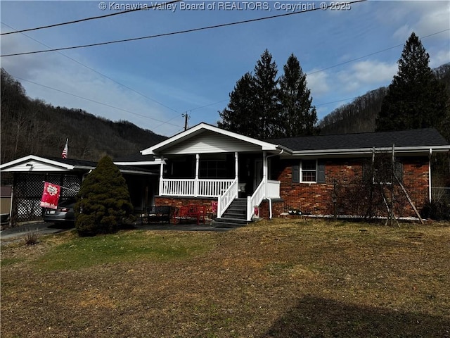 view of front of property with brick siding, a front yard, and covered porch