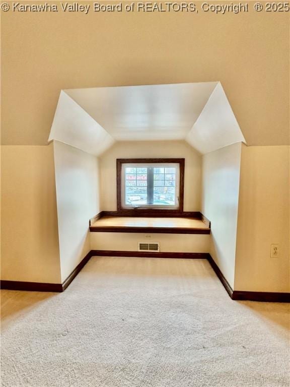 additional living space with lofted ceiling, baseboards, visible vents, and carpet flooring