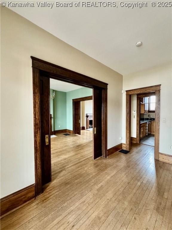 spare room featuring light wood-style floors and baseboards