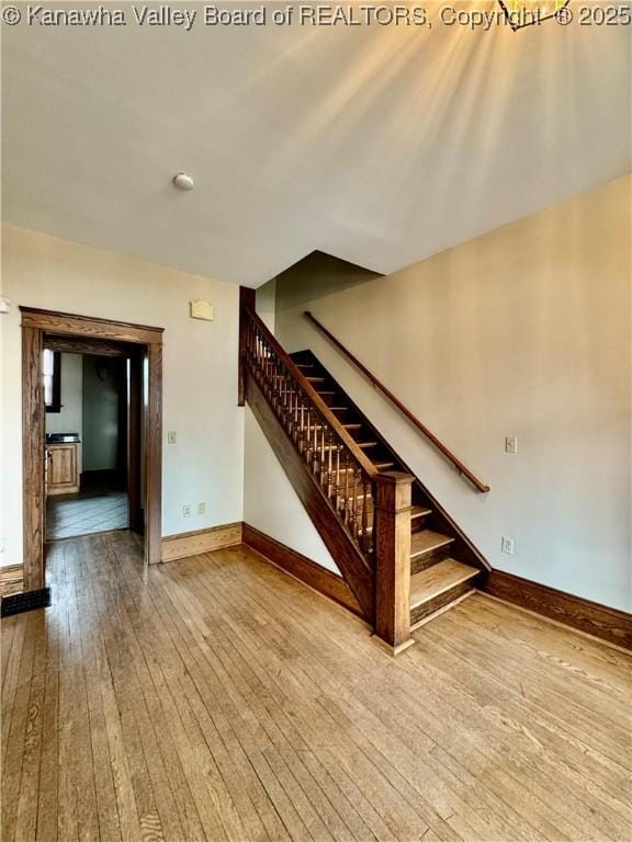 interior space featuring stairway, wood finished floors, and baseboards