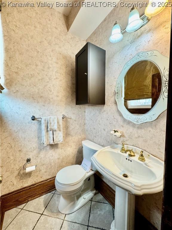 bathroom with tile patterned flooring, toilet, and baseboards