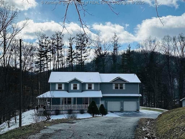 view of front of property with a garage, aphalt driveway, and a porch