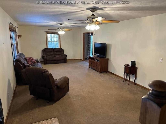 living room featuring a ceiling fan, baseboards, a textured ceiling, and light colored carpet