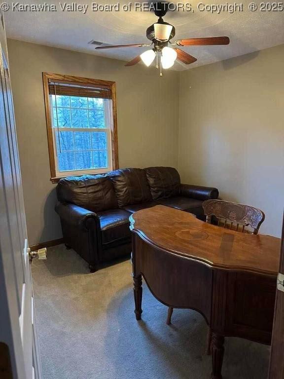 sitting room featuring light carpet, ceiling fan, a textured ceiling, and baseboards