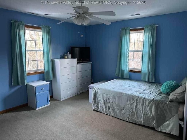 bedroom with light carpet, multiple windows, visible vents, and a ceiling fan