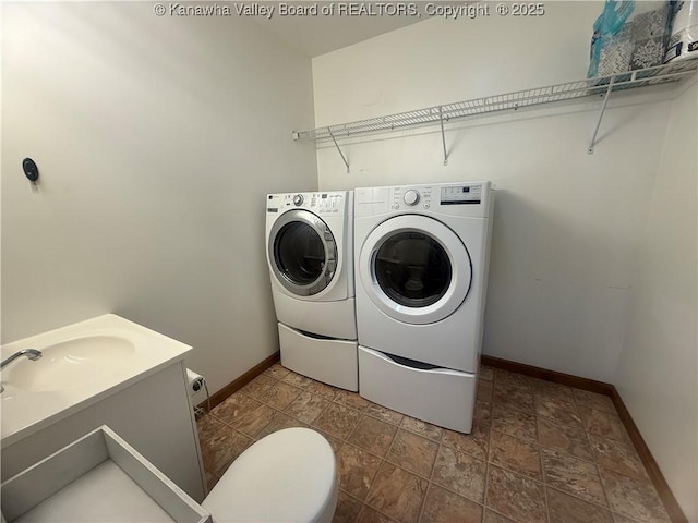 laundry room with laundry area, baseboards, and washer and clothes dryer