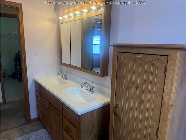 bathroom with double vanity, a sink, and a walk in closet