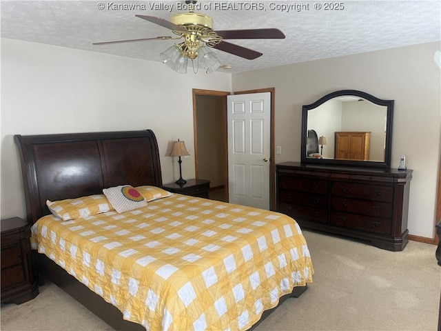 bedroom featuring a ceiling fan, light colored carpet, a textured ceiling, and baseboards