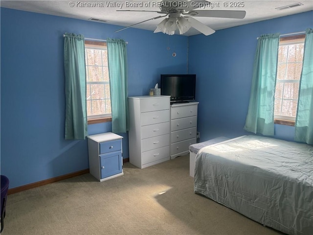 bedroom featuring light carpet, ceiling fan, visible vents, and baseboards