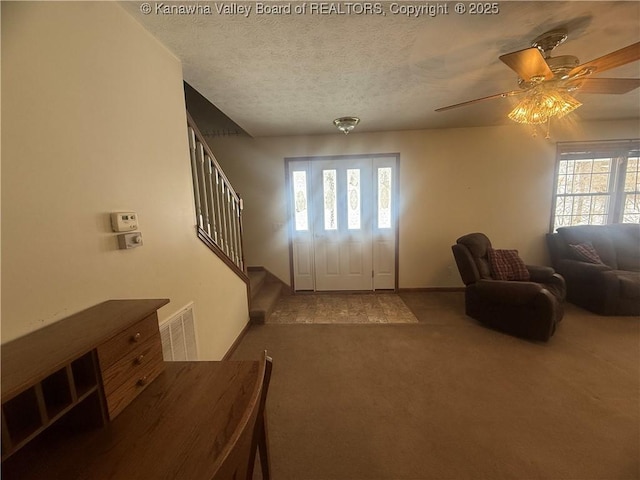 foyer featuring carpet floors, stairway, plenty of natural light, and visible vents