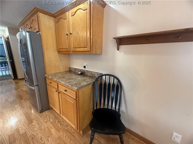 kitchen featuring open shelves, brown cabinets, freestanding refrigerator, and light wood-style floors