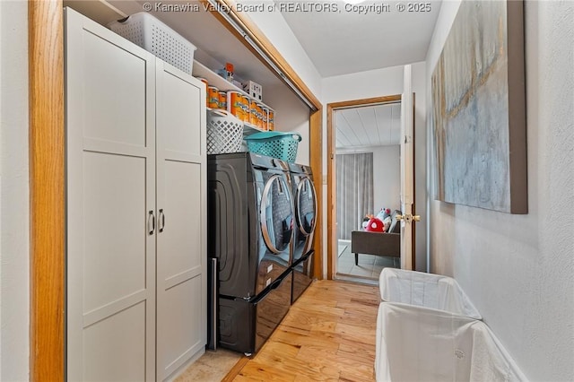 clothes washing area with light wood-type flooring and washer and dryer