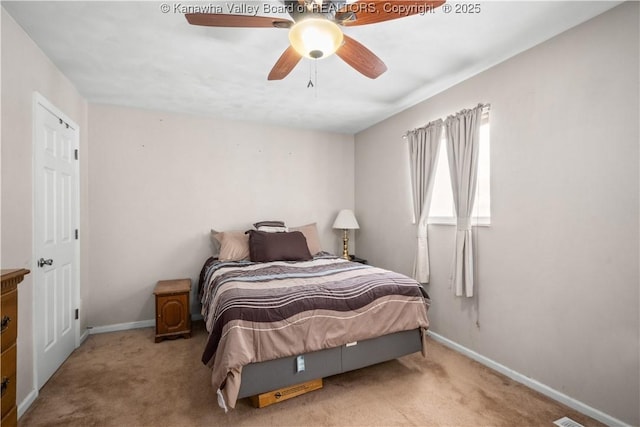 bedroom featuring a ceiling fan, light colored carpet, and baseboards