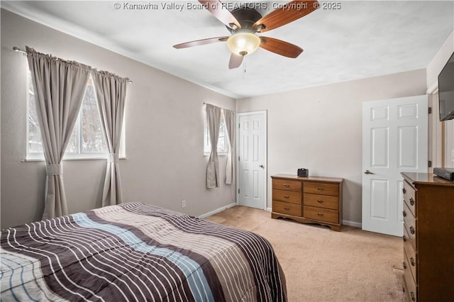 bedroom with multiple windows, light carpet, and baseboards