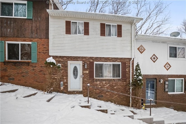 tri-level home featuring brick siding