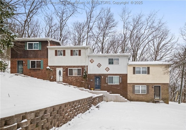 tri-level home featuring entry steps and brick siding