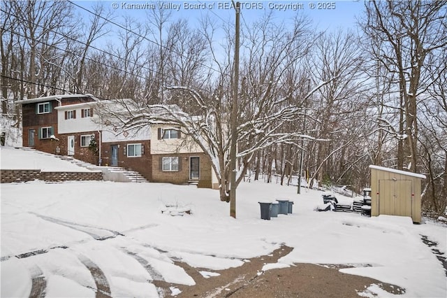 yard layered in snow featuring an outdoor structure and a storage shed