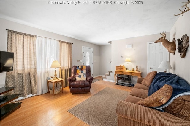 living area featuring stairway, baseboards, and wood finished floors