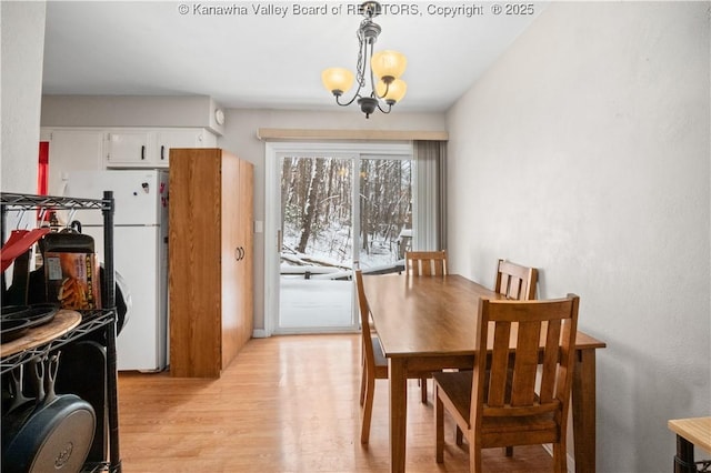 dining room with a chandelier and light wood finished floors