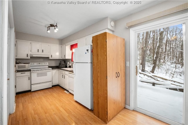 kitchen featuring under cabinet range hood, white appliances, a sink, white cabinets, and light wood-type flooring