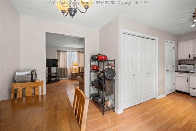 dining area featuring light wood-style flooring and baseboards