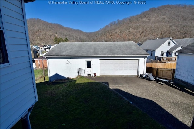 detached garage featuring fence and a mountain view