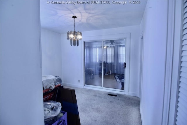 interior space featuring baseboards, carpet, visible vents, and a notable chandelier