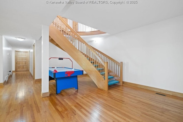 recreation room featuring visible vents, baseboards, and wood finished floors