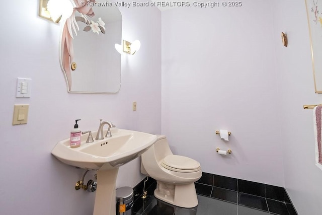 bathroom with toilet and tile patterned floors