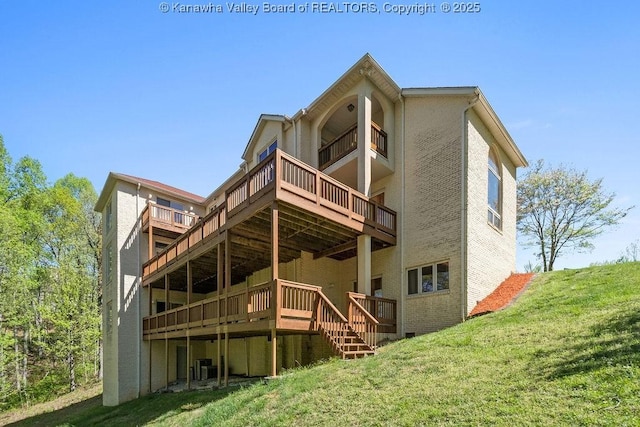 back of property with brick siding, central AC unit, a lawn, and stairway