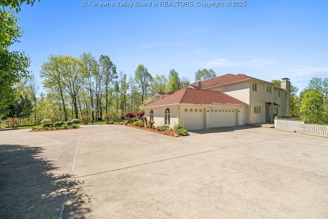 view of side of home with a garage and driveway