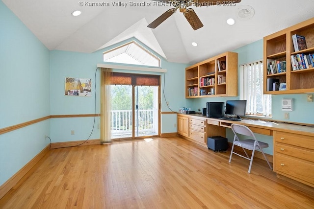 unfurnished office featuring a ceiling fan, baseboards, vaulted ceiling, light wood-type flooring, and built in study area