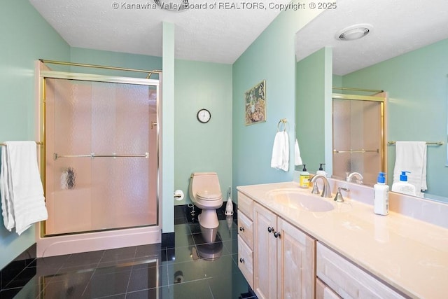 bathroom featuring toilet, a stall shower, vanity, and tile patterned floors