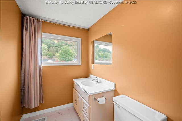 bathroom featuring marble finish floor, baseboards, vanity, and toilet