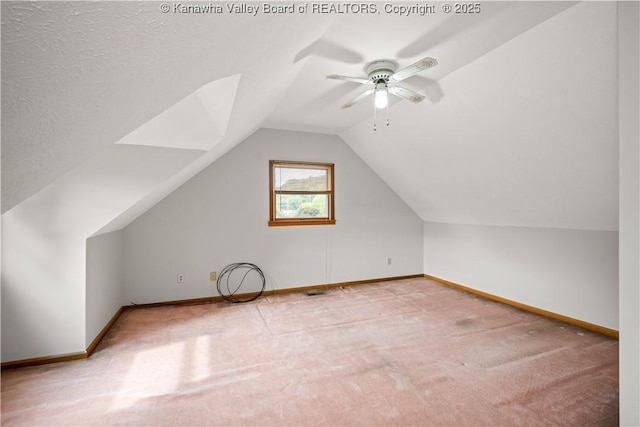 additional living space with light carpet, vaulted ceiling, baseboards, and ceiling fan