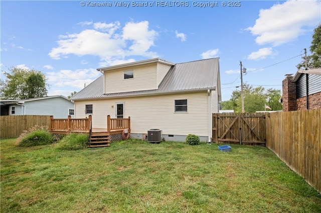 back of property with a deck, a yard, crawl space, and a fenced backyard