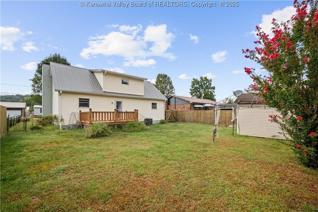 back of property featuring a fenced backyard, a lawn, and a deck