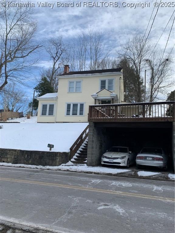 view of front of property featuring a chimney, stairway, and a wooden deck