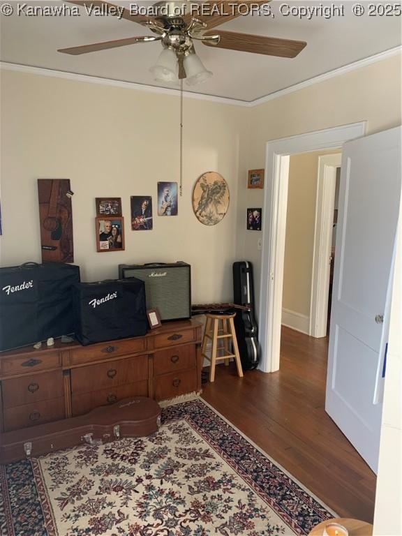 office space featuring ornamental molding, dark wood finished floors, and a ceiling fan