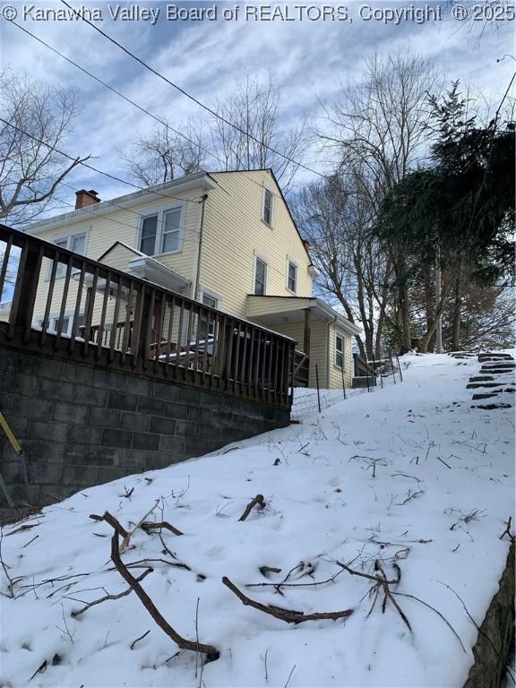 snow covered property with a deck