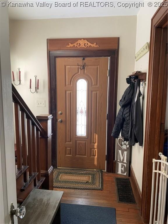 foyer entrance with stairway, wood finished floors, and visible vents