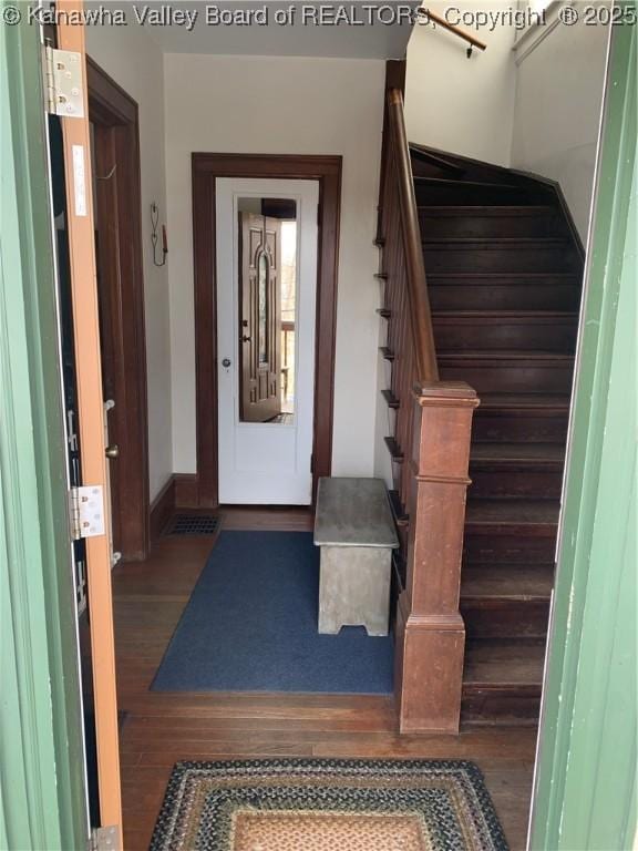 entryway with dark wood-style floors, stairway, and baseboards