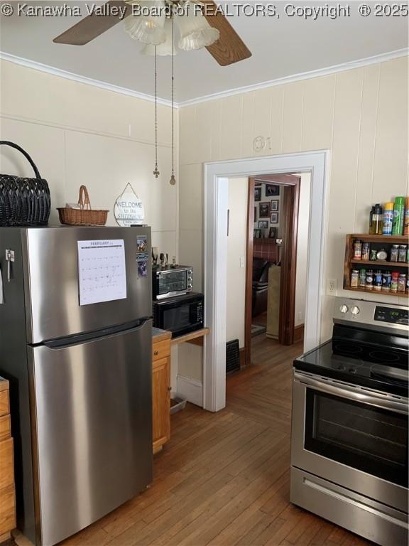 kitchen featuring ceiling fan, stainless steel appliances, and crown molding