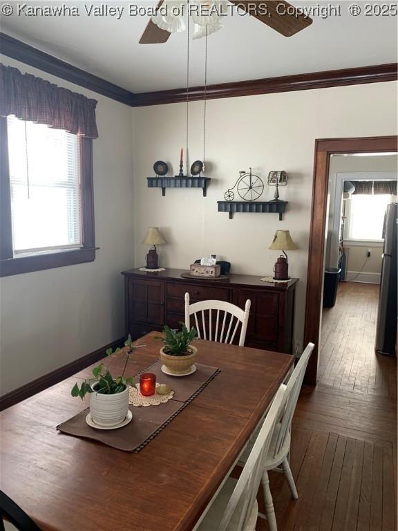 dining room with baseboards, dark wood-style flooring, a ceiling fan, and crown molding