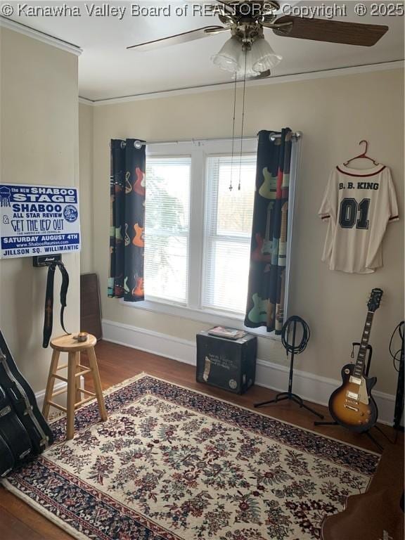 interior space featuring baseboards, ceiling fan, wood finished floors, and crown molding