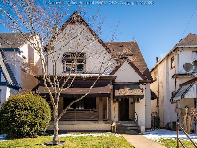 view of front of property with a shingled roof, a front yard, and stucco siding