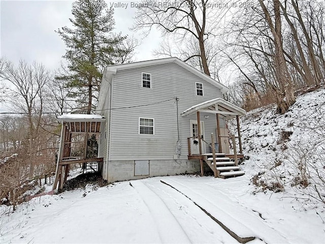 view of snow covered back of property